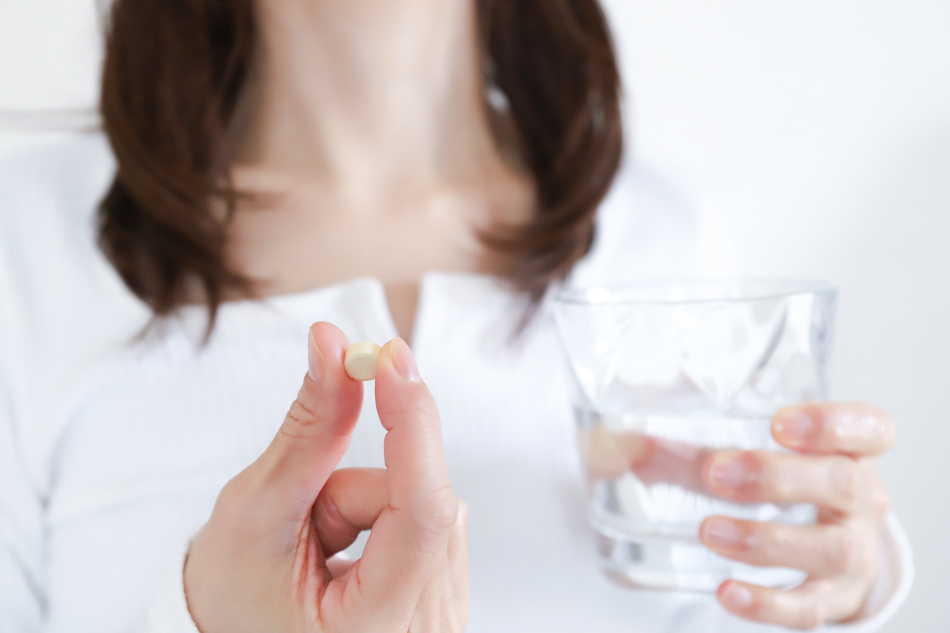 薬を飲む女性