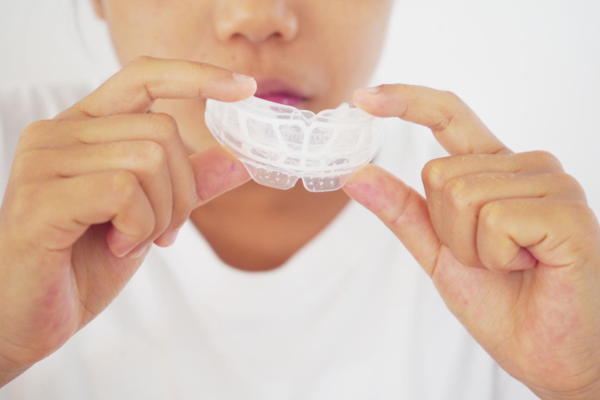 マウスピースを持つ子どもの手