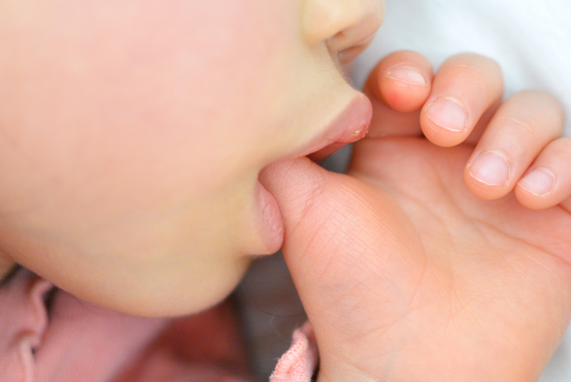指しゃぶりをする子供の横顔