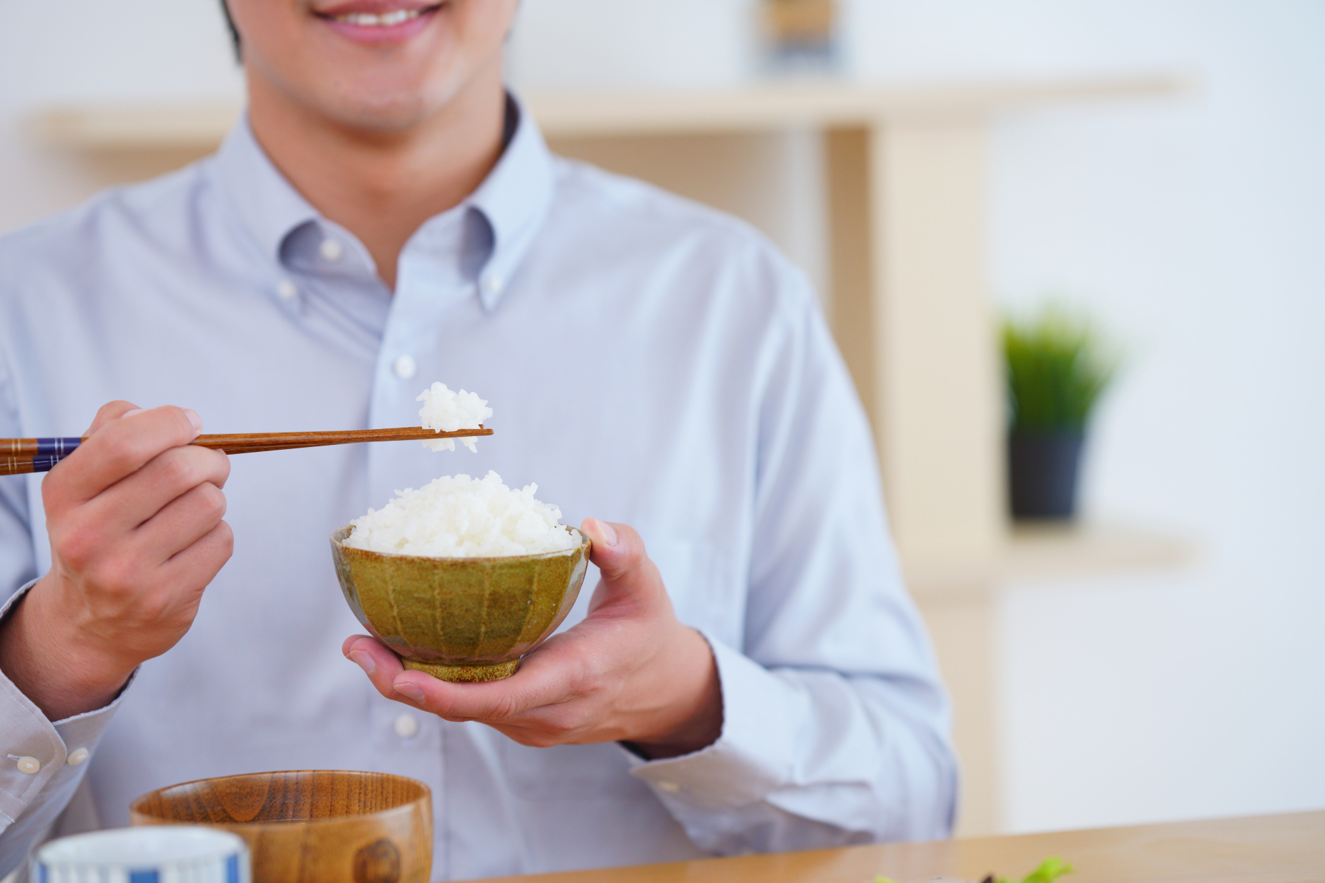 ごはん茶碗を持つ人の手