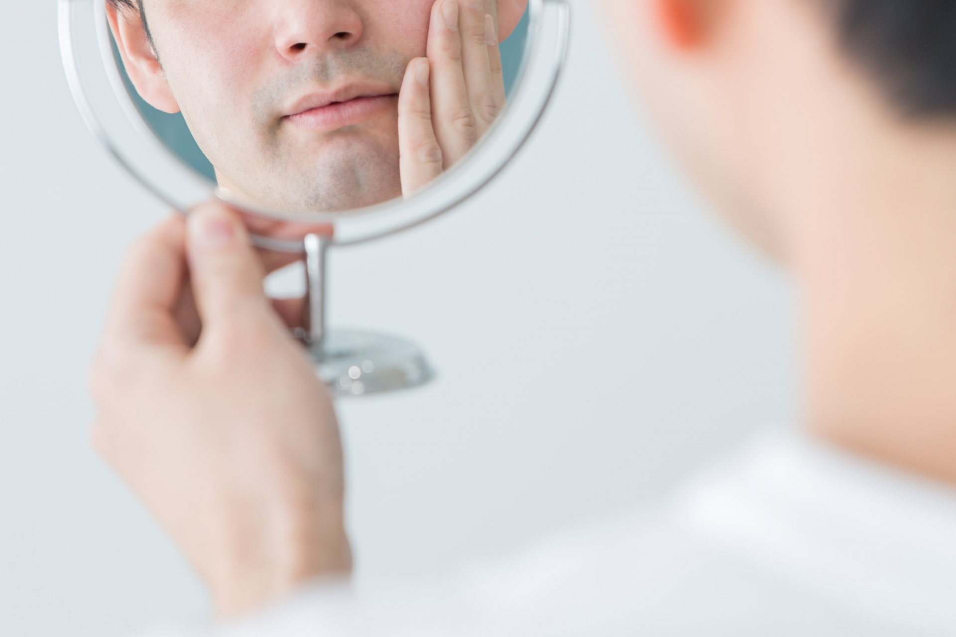 鏡を見て歯をチェックする男性
