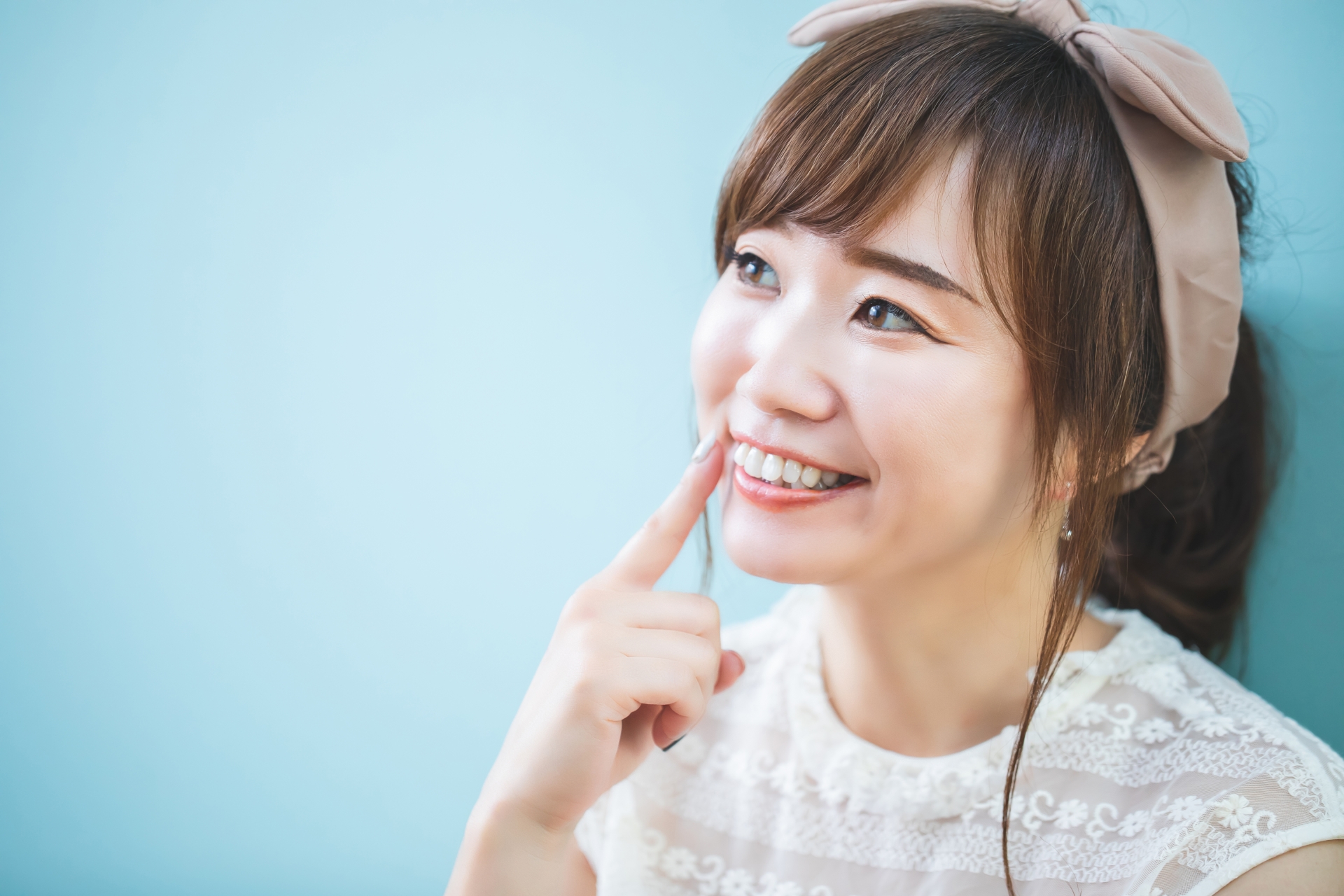 口元を指差す女性