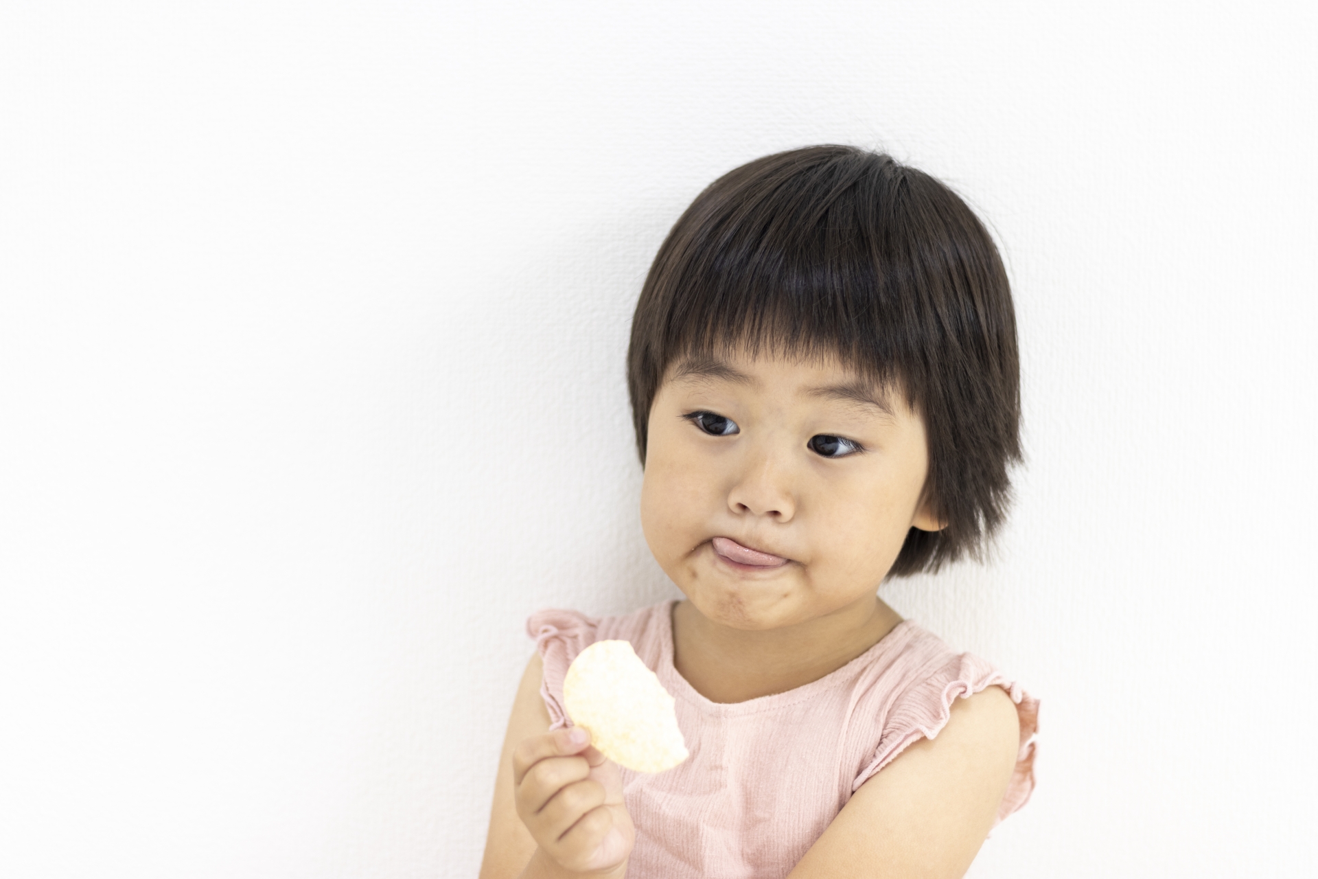 ポテトチップスを食べて舌を出す女の子