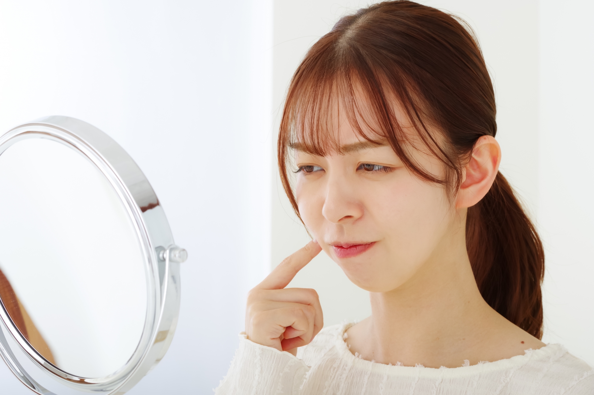 口のトラブルを気にする若い女性