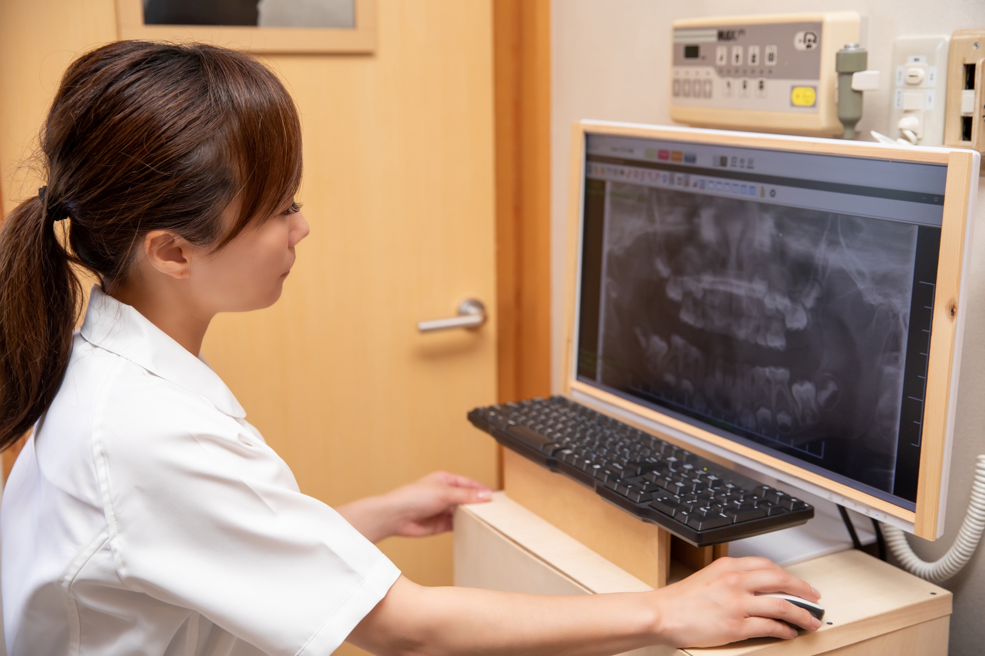 歯のレントゲン写真を見る女性医療従事者