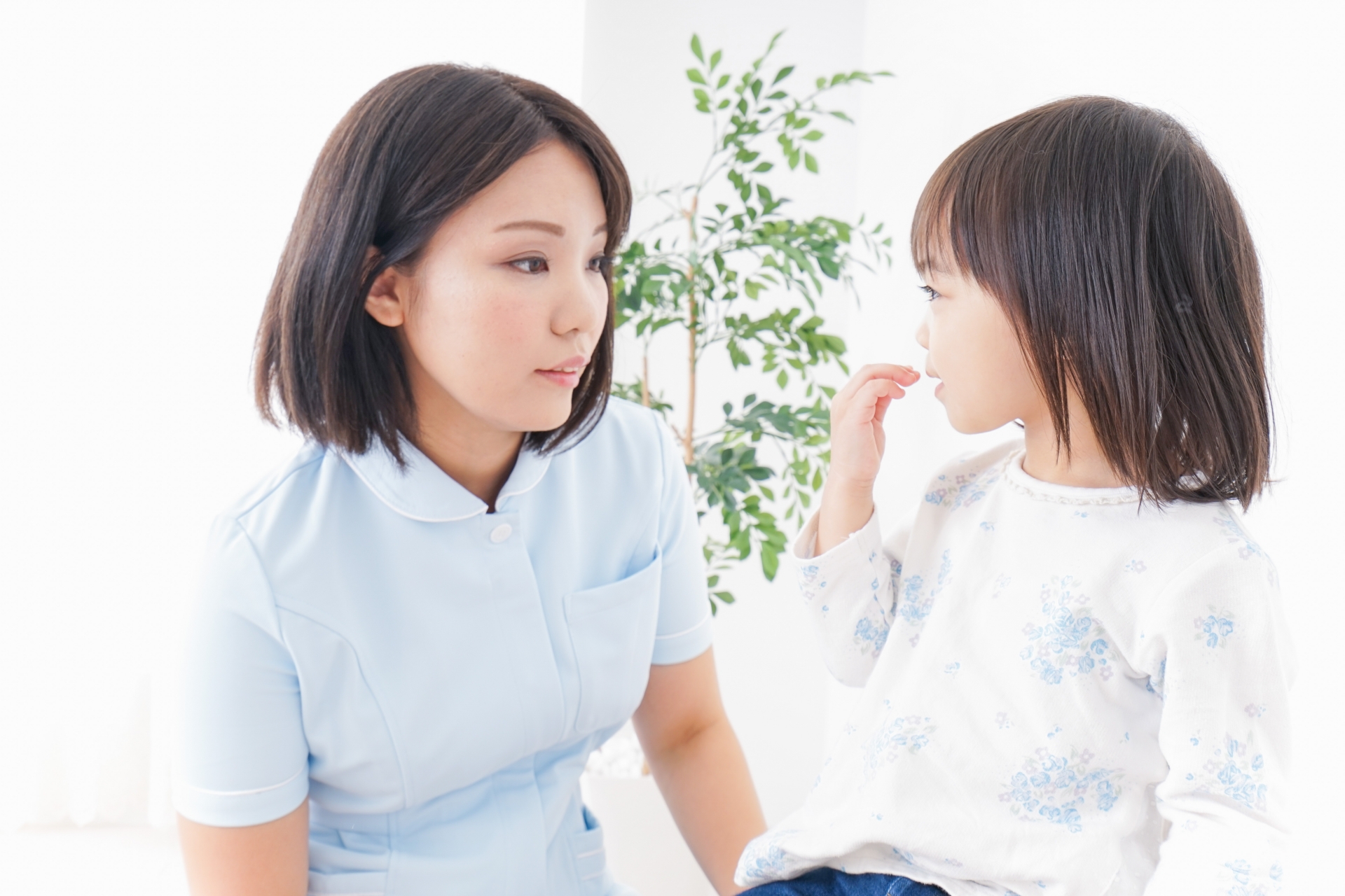 女児と見つめ合う女性歯科医師